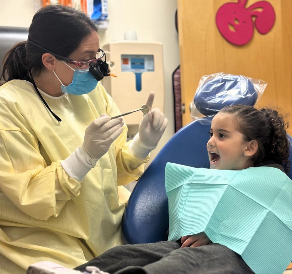 Child in dental chair opening wide